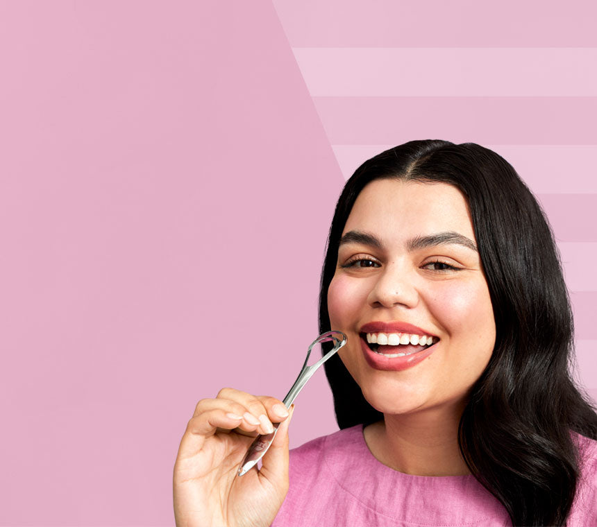 Smiling girl in pink with a stainless steel tongue scraper