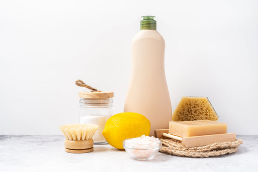 A collection of eco-friendly cleaning supplies, including a natural sponge, baking soda, and lemon. 